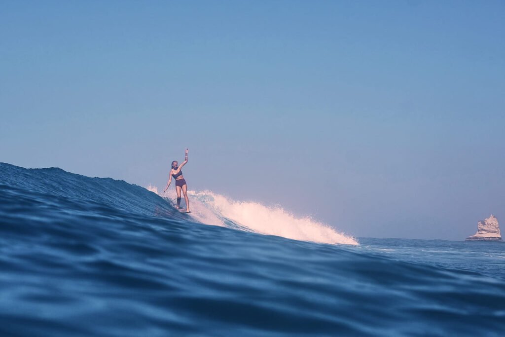 G Fish hanging ten in front of a white pinnacle like cliff in Indonesia