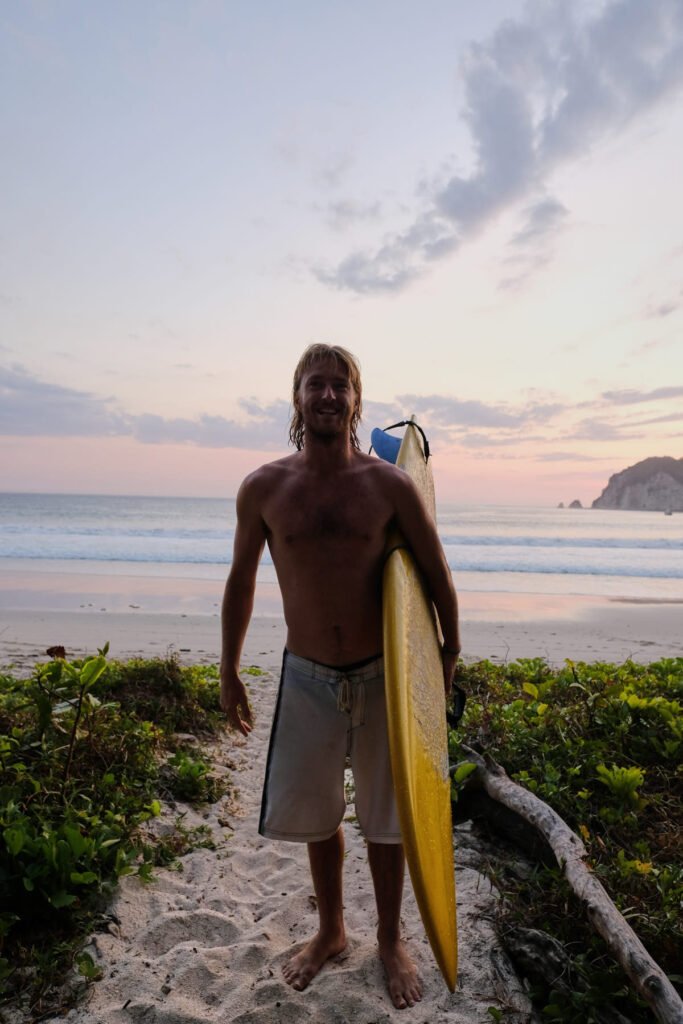 Dylan Price all smiles as the sunsets on another dreamy Indonesian day. Standing in front of a beautiful bay.