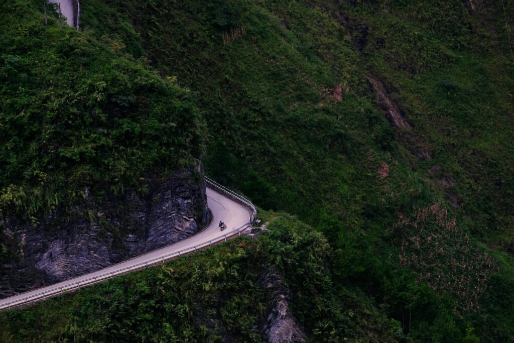 A lone motorbiker cuts through Ma Pi Leng pass with huge hillsides