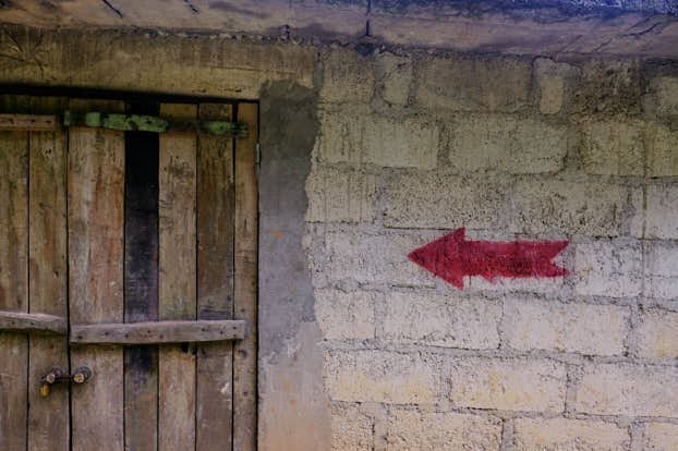 A read arrow on brick building indicating the way