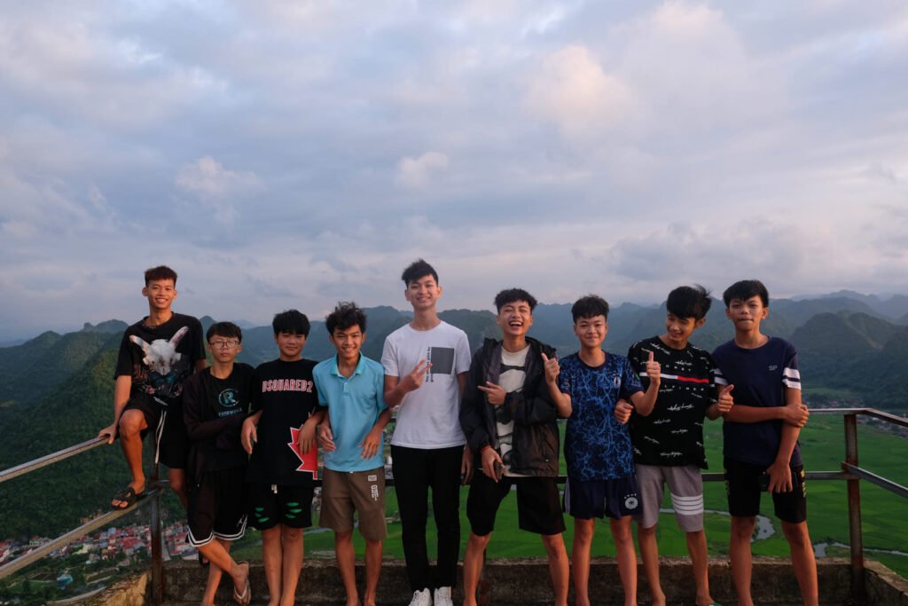 A group of young teenagers with all sorts of expressions on top of Na Lay Mountain