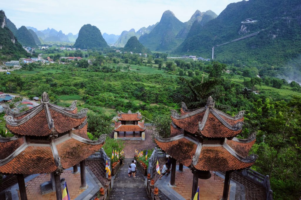 The pagodas of Ban Gioc Temple, situated on the hillside opposite the valleys of the surrounding region. A steep stretch of stairs run through the middle down to the bottom pagoda, kids play in the middle. A place that has a sacred feel to it.