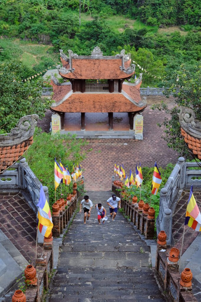 Kids run up the steep steps of Ban Gioc temple. The architecture is traditional.