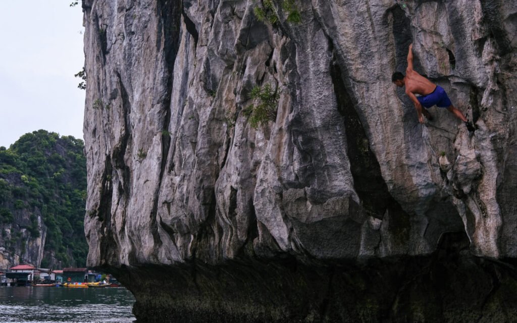 A climber hangs on casually and cool-ly above the water in Cat Ba island. Looking confident but also insignficant.