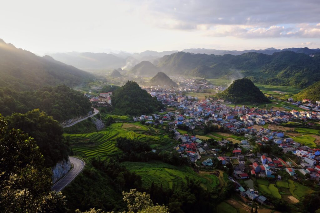 The aptly named 'Heaven Gate'. A small colourful village full of red and light blue buildings sit amongst a landscape of impressive limestone karst mountains.