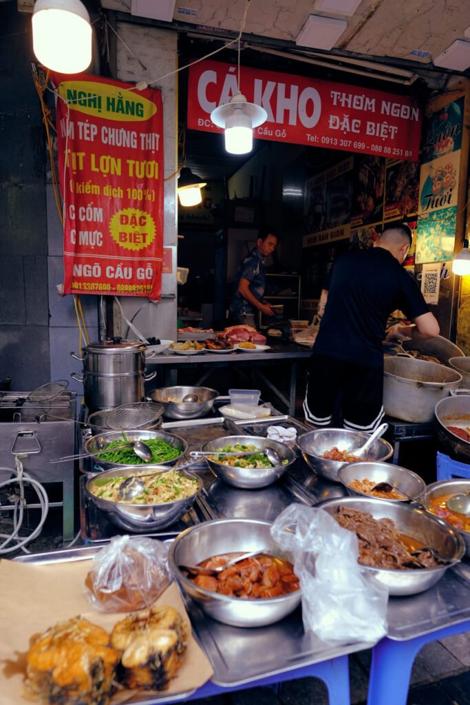 Streetside in Hanoi, plates of food line the tables all the way out to the edge of the footpath