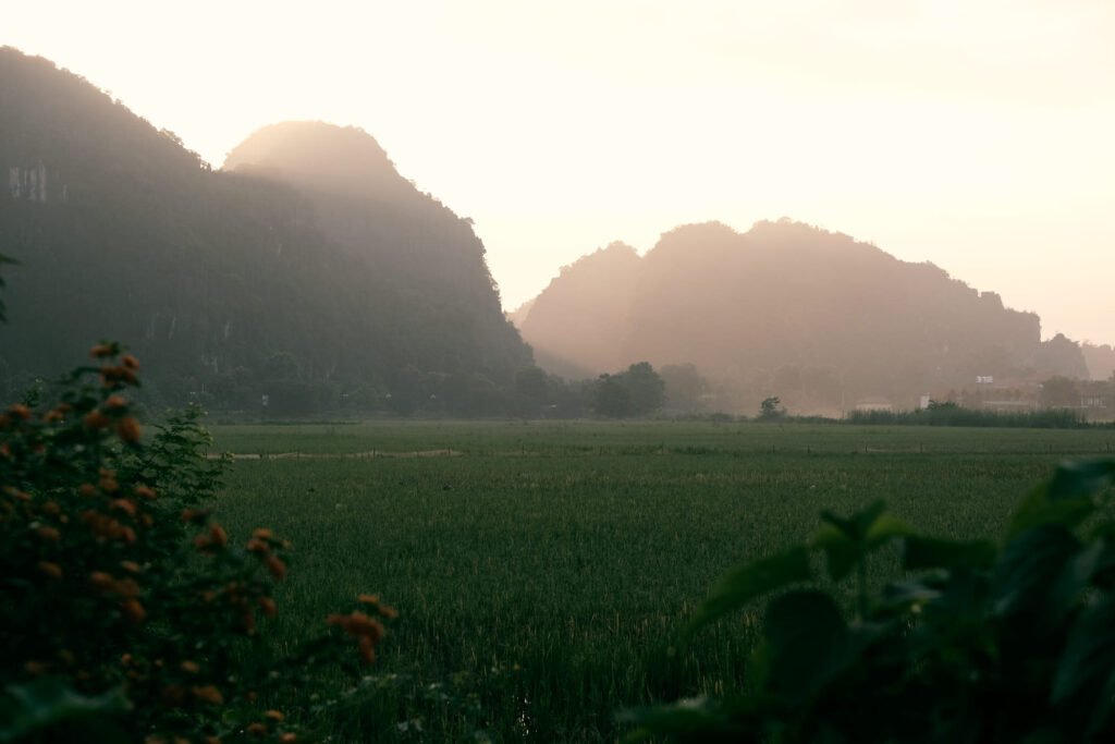 Sunrise in the valley of Tam Coc, Vietnam. Splitting through the mountains and glowing orange.