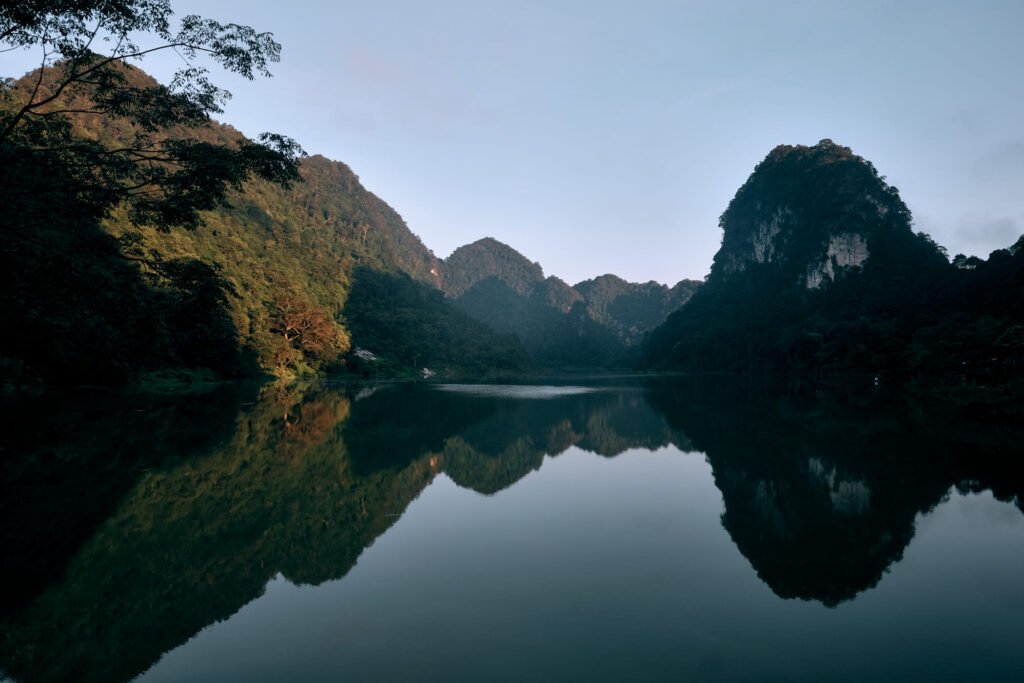 Mirror reflections of Lake Thang Hen. Karst mountains reflecting in the still morning.