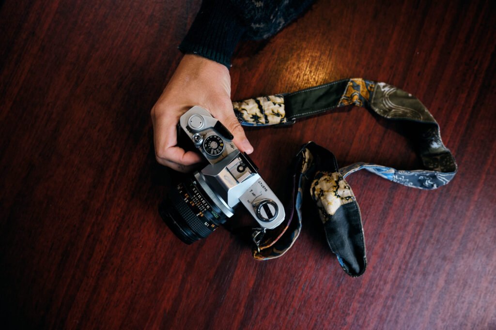 Hand reaches out to grab vintage film camera ready to shoot